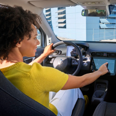 Driver using touchscreen controls inside a car.