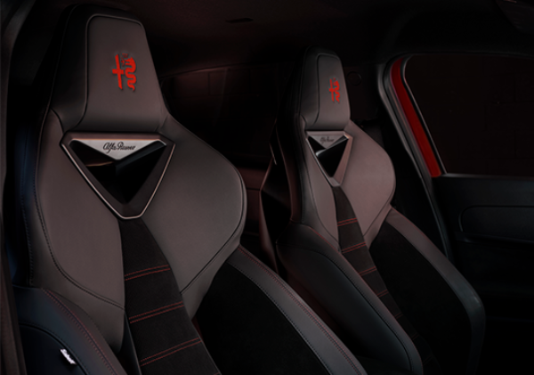 Black sports car seats with red stitching and logo embroidery.