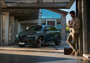 Man standing by a parked SUV in a garage setting.