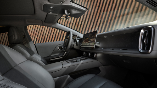 Interior of a car with black leather seats and a dashboard touchscreen display.