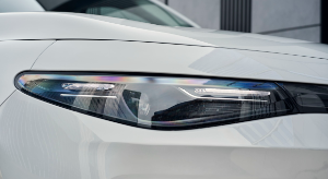 Close-up of a white car's headlight with a sleek, modern design.