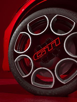 Close-up of a Peugeot GTI alloy wheel with circular spoke design and Michelin tyre.