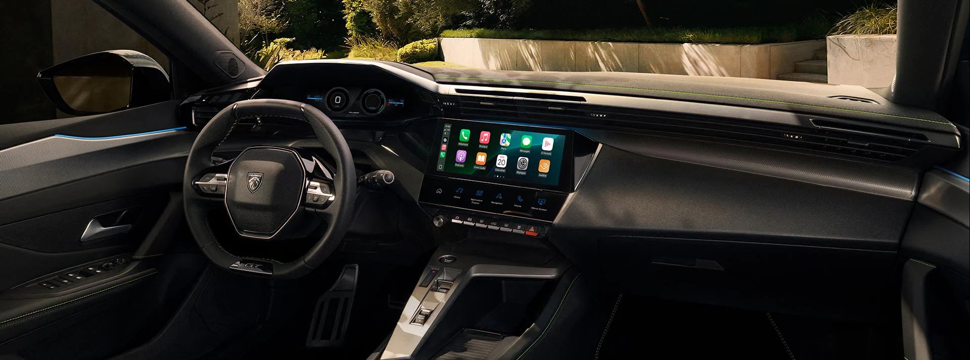 Car interior featuring a touchscreen display and a steering wheel.