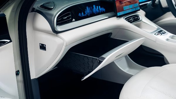 Car interior with open glove compartment and digital display on the dashboard.
