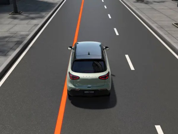 A silver car driving on a city road, viewed from behind.