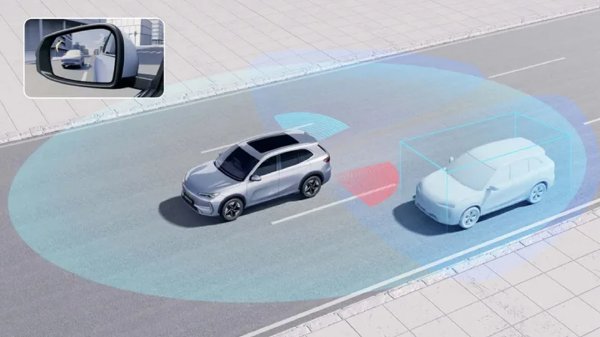 Silver car using blind spot detection technology on the road.