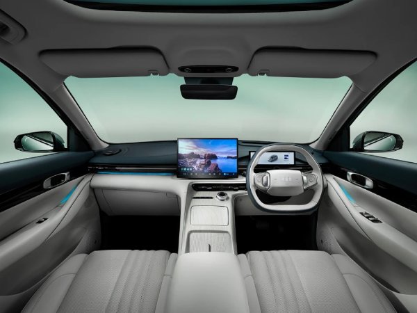 Interior view of a modern car showing seats, steering wheel, and dashboard screens.