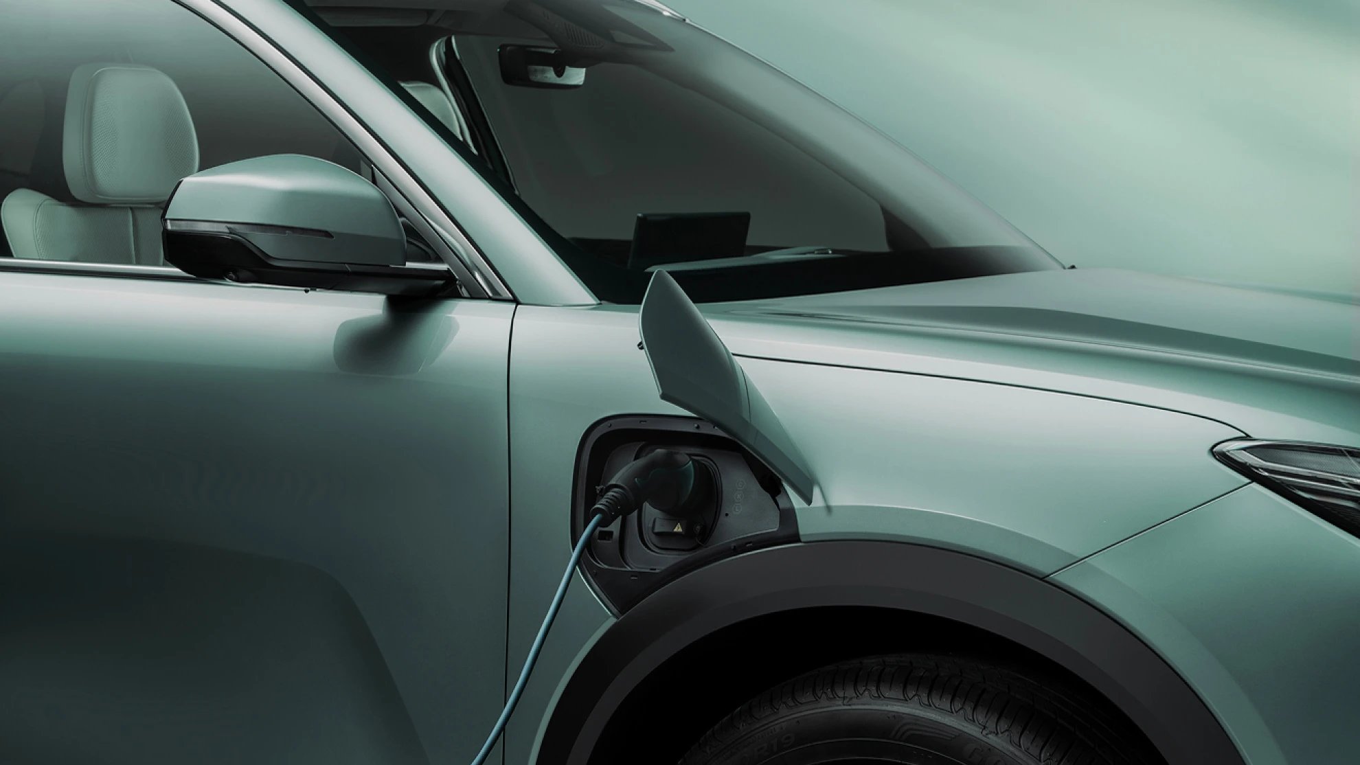 Electric car charging with cable plugged into the side.