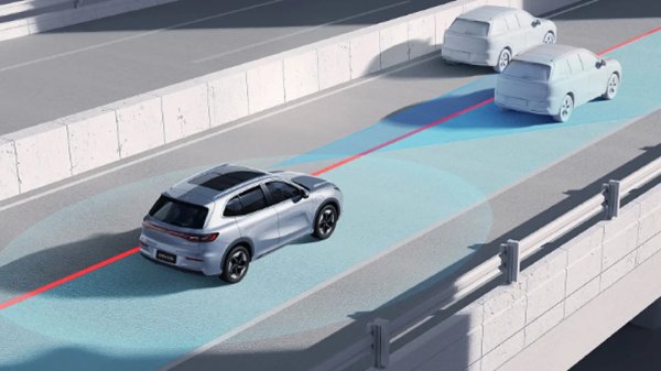 Silver car with sensors and laser guiding system on a road alongside two indistinct vehicles.