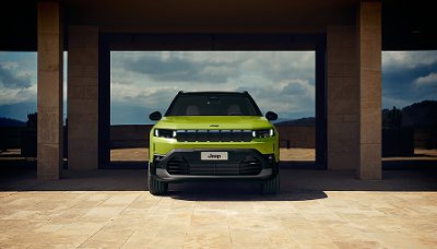 Front view of a bright green Jeep parked under a structure.