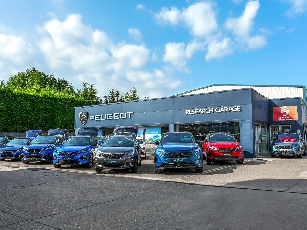 Peugeot cars displayed outside a dealership named Research Garage.