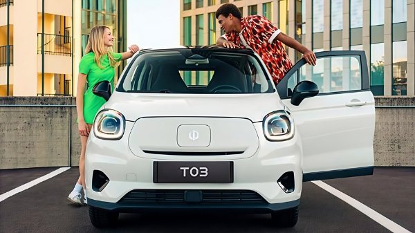 Two people with a white compact car, doors open, in an urban setting.