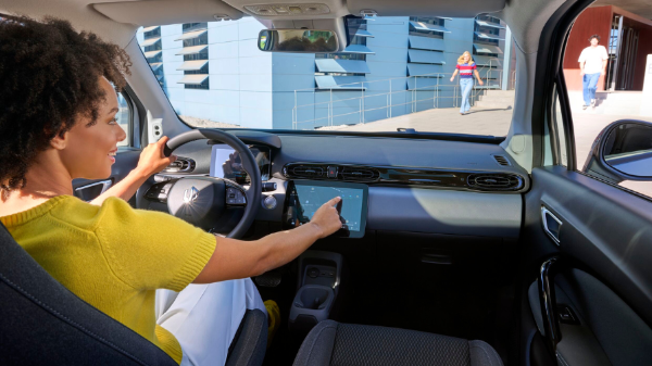 Person in car using the touchscreen controls on the dashboard.